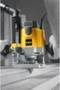 A person wearing gloves is using a DeWALT router on a textured surface. Produktbild-Vorschau