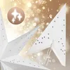A close-up view of two white paper stars decorated with sequins, set against a blurred golden background with bokeh lights. Produktbild-Vorschau