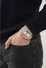 A person's hand with a watch on their wrist is in the pocket of their jeans. Náhled obrázku produktu