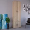 A tall, narrow wardrobe with two doors on top and two doors on the bottom, standing in a room with a painting and a chair. Náhľad obrázku produktu