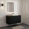 A modern black vanity with a white sink and a large illuminated mirror in a bathroom with marble tiles. Anteprima dell’immagine prodotto