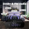A Denver radio alarm clock is shown in a bedroom setting, with text overlay highlighting its DAB+ and FM radio features. Podgląd zdjęcia produktu