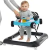 A baby is in a blue and black baby walker designed to look like a race car. An adult's hands are visible, holding the walker. Náhled obrázku produktu