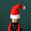 A close-up of a wine bottle wearing a Santa hat and scarf. Náhled obrázku produktu