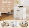 A white nightstand with two drawers is shown next to a bed, with lifestyle images of a living room, bedroom, and home office at the bottom. Podgląd zdjęcia produktu