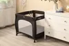 A baby playpen is placed next to a white dresser in a room. Anteprima dell’immagine prodotto