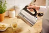 A hand is pouring hot water from a Philips kettle into a glass mug with a tea bag. Náhľad obrázku produktu