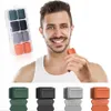 A man smiling and holding a jaw exerciser, with a set of jaw exercisers in a case in the background. Below are four individual jaw exercisers in different colors. Náhľad obrázku produktu