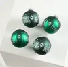 Four green Christmas ornaments with white festive designs are arranged on a white surface. Produktbild-Vorschau