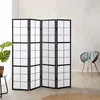 A room divider is set up in a room with a chair and a plant. Voir les images du produit