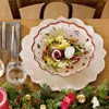 A festive Christmas table setting with a salad bowl, cutlery, and Christmas decorations. Voir les images du produit