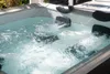 A close-up view of a bubbling hot tub filled with clear water, set outdoors. Náhľad obrázku produktu