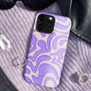 A phone case with a wavy pattern is placed on a purple knitted fabric, next to sunglasses and rings. Podgląd zdjęcia produktu