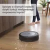 A robot vacuum cleaner is cleaning a wooden floor, with a person in the background. Voir les images du produit