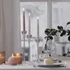 A table setting with lit candles, wine glasses, and a plant. Produktbild-Vorschau