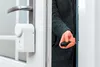A person is holding a key fob to unlock a smart door lock. Náhľad obrázku produktu