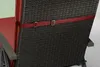 Close-up of a red strap attached to a dark woven chair back. Produktbild-Vorschau