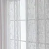 A close-up view of sheer curtains hanging in front of a window. Produktbild-Vorschau