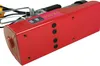 A close-up, angled view of the bottom and side of a red electric winch, with some cables visible. Podgląd zdjęcia produktu