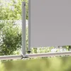 A close-up view of a gray retractable side awning attached to a railing on a balcony or patio, with blurred green foliage in the background. Anteprima dell’immagine prodotto