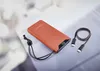 An orange power bank with a digital display showing '90' and a black USB-C cable is placed on a light gray surface with a blurred background. Voir les images du produit