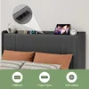 A bed with a headboard featuring integrated charging ports and storage, with pillows and bedding. Anteprima dell’immagine prodotto