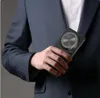 A person in a suit holding a phone case. Produktbild-Vorschau