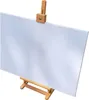 A white canvas on a wooden easel against a white background. Produktbild-Vorschau