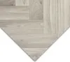 A close-up view of a light gray wood-look flooring material arranged in a chevron pattern. Produktbild-Vorschau