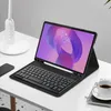 A tablet with a keyboard case and stylus is placed on a white desk next to a lamp and a cup of coffee. Produktbild-Vorschau