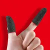 Close-up of two fingers wearing black gaming finger sleeves with red trim, against a red background. Produktbild-Vorschau