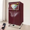 A burgundy electric clothes dryer stand with clothes hanging inside, shown in a room with a remote control in the foreground. Náhled obrázku produktu
