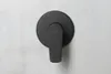 A close-up of a black matte shower faucet handle mounted on a textured gray wall. Anteprima dell’immagine prodotto
