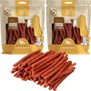 Two bags of dog treats with a pile of treats in front. Produktbild-Vorschau