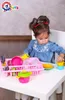 A young girl is playing with a toy kitchen set on a table. Náhľad obrázku produktu