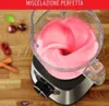 A blender with pink contents on a wooden surface, with some fruits in the background. Voir les images du produit