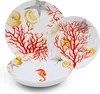 A set of white ceramic plates and bowls with a coral and seashell pattern. Voir les images du produit