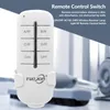 A white remote control with multiple buttons is shown in the foreground, with a blurred background of what appears to be a tank or industrial machinery. Náhľad obrázku produktu