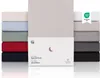 A stack of fitted sheets in various colors, with a product package in the foreground. Anteprima dell’immagine prodotto