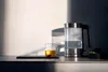 A glass electric kettle and a mug of tea are on a countertop, with sunlight casting shadows on the wall. Anteprima dell’immagine prodotto