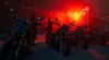 Motorcycles parked in a dimly lit venue with red neon lighting. Produktbild-Vorschau