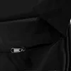 A close-up view of a black fabric bag, showing a zipper and a velcro closure. Podgląd zdjęcia produktu