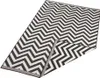 A black and white chevron patterned rug is shown from a diagonal angle, with one corner folded back. Voir les images du produit