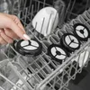 A hand places a reusable coffee filter into a dishwasher. Produktbild-Vorschau