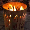 A fire pit with flames burning inside, set on a paved surface with fallen leaves in the background. Produktbild-Vorschau