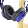 A close-up of blue and black headphones resting on a wooden stand. Anteprima dell’immagine prodotto