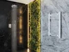 A modern bathroom with a black marble shower, a vertical garden, and a white towel warmer. Náhľad obrázku produktu