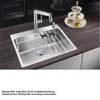 A stainless steel kitchen sink with a modern faucet and a tiered stand with appetizers on a dark wood countertop. Náhled obrázku produktu