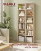 A living room scene with a VASAGLE bookshelf filled with decorative items and books, next to a sofa and a coffee table. Produktbild-Vorschau
