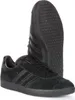 A pair of black Adidas Gazelle sneakers are shown against a white background. One shoe is placed in the foreground, angled to show its side profile and laces. The other shoe is placed behind it, angled to show its sole. Voir les images du produit